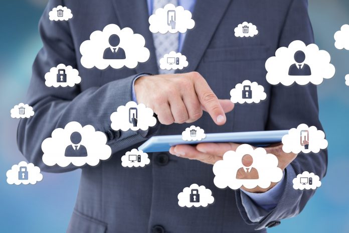 Composite image of businessman holding and using tablet computer